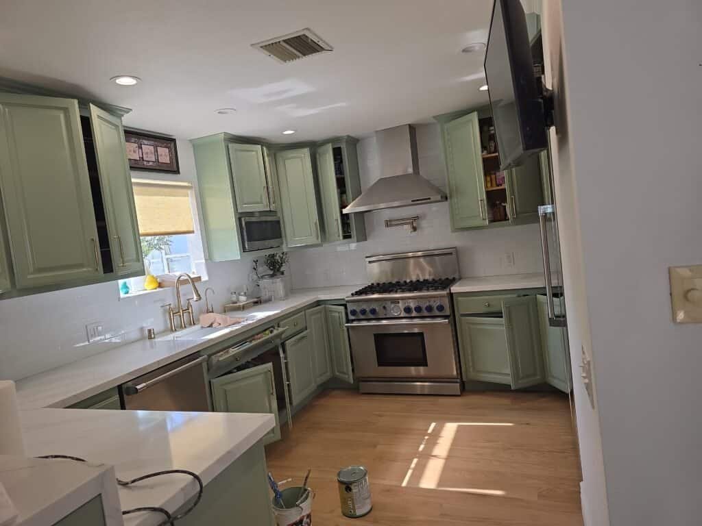 Bright lime green kitchen cabinets with white countertops and stainless steel appliances, including a range and microwave, featuring modern cabinetry and a clean, stylish design.