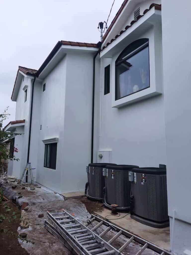 White exterior house painting with modern windows and a freshly painted facade, showcasing professional residential painting services by AAF Painting Inc.